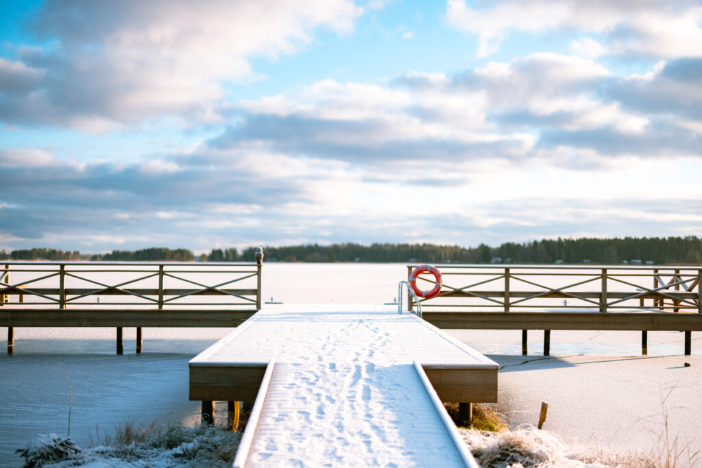 En snötäckt brygga i en istäkt sjö.